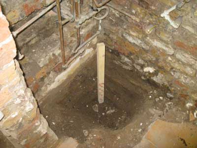 Sump hole in damp floor  of basement